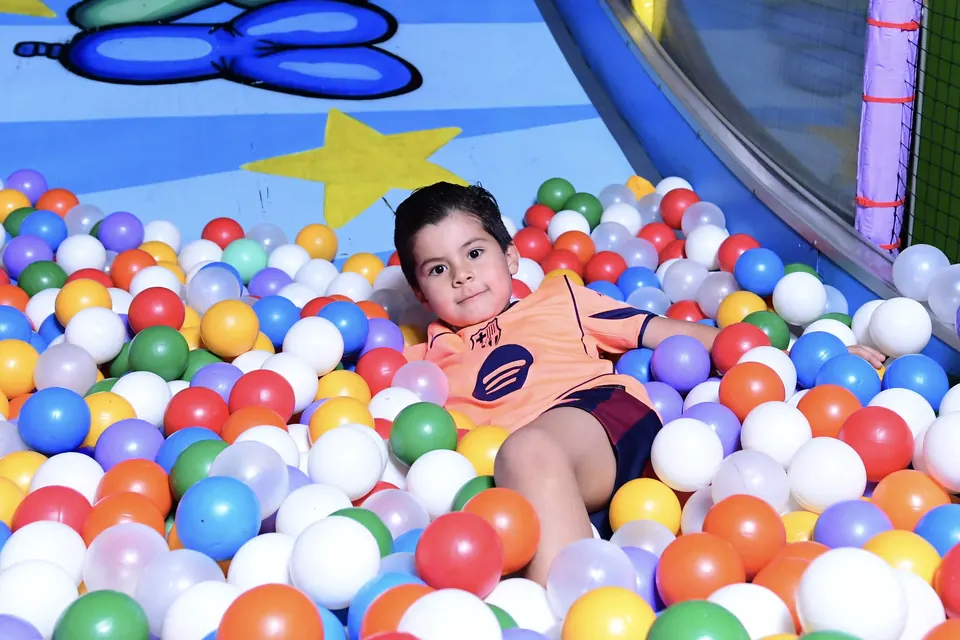 Niño jugando entre las pelotas de colores