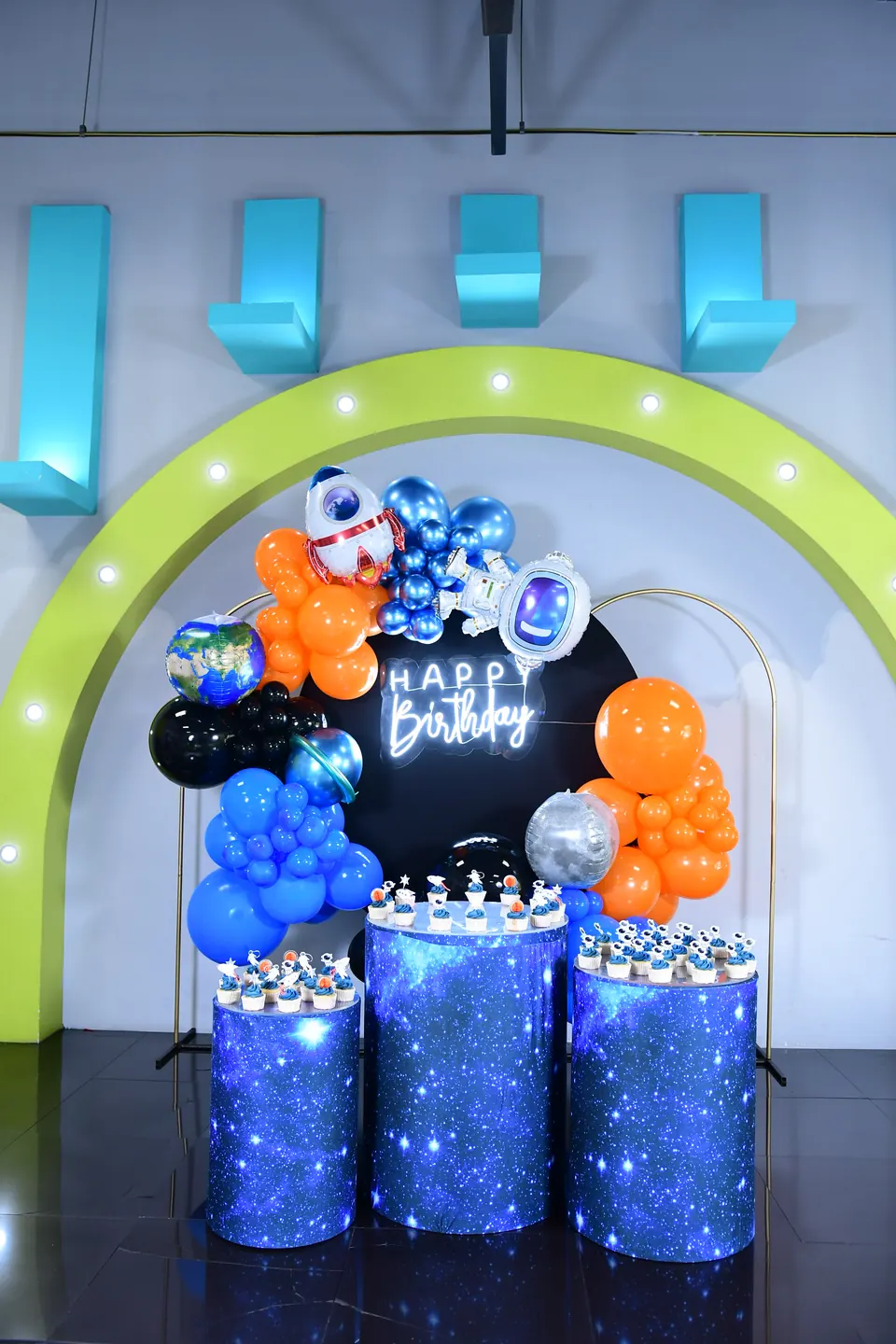 Montaje espacial con globos azules, naranjas y plateados