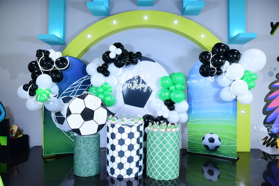 Montaje futbolero con balones y globos verdes y negros