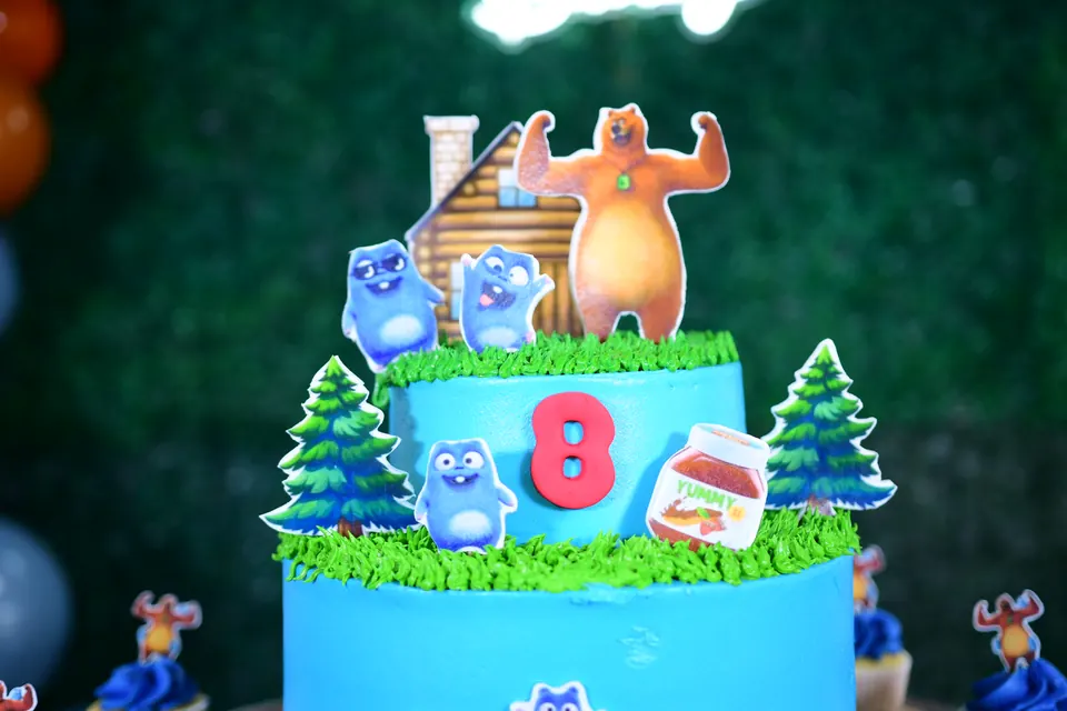 Pastel de dos pisos con personajes y bosque