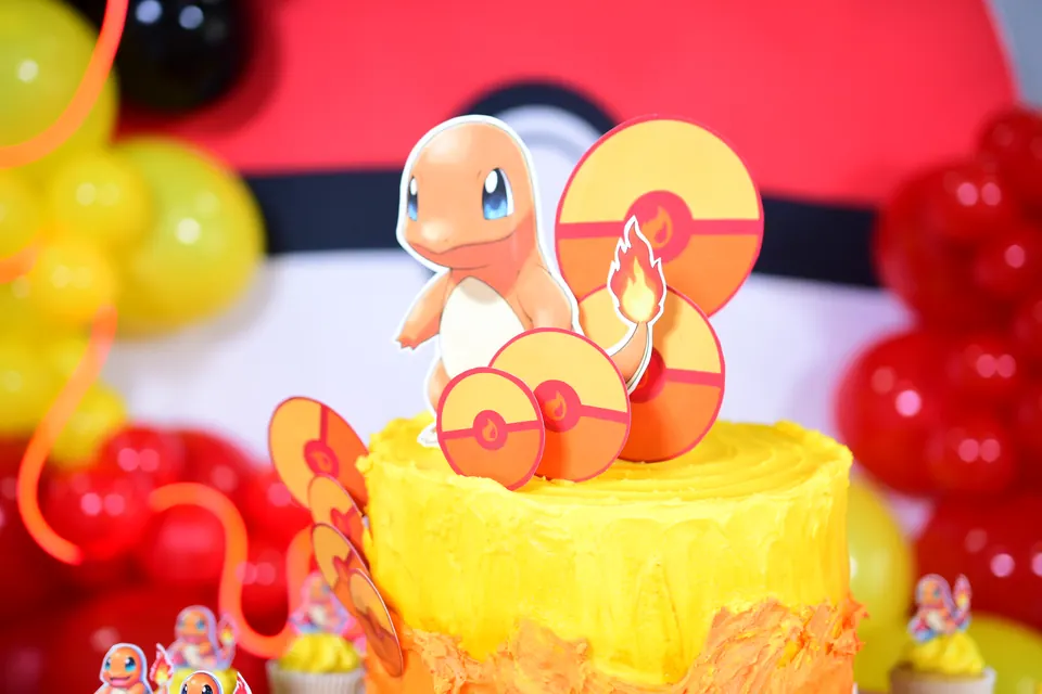 Pastel amarillo con figura de Pokémon y globos rojos