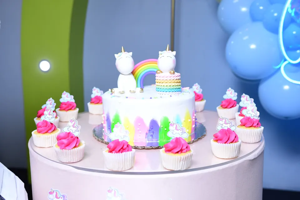 Pastel de unicornio con arcoíris y cupcakes alrededor